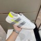 Moncler Montpellier Trainer Lateral Side View in white and grey Handheld lateral view of Moncler Montpellier trainer detailing the neon yellow logo and grey stripes in white and grey