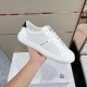 Side view of white Moncler trainer held in hand showing perforated panel