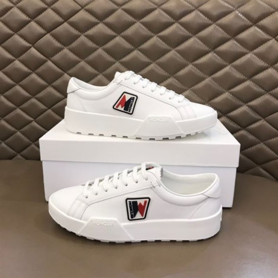 Pair of Moncler Promyx white leather trainers displayed on and beside a shoe box