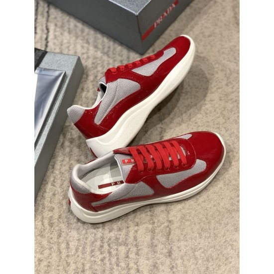 Pair of red and grey Prada America's Cup trainers resting on carpeted surface