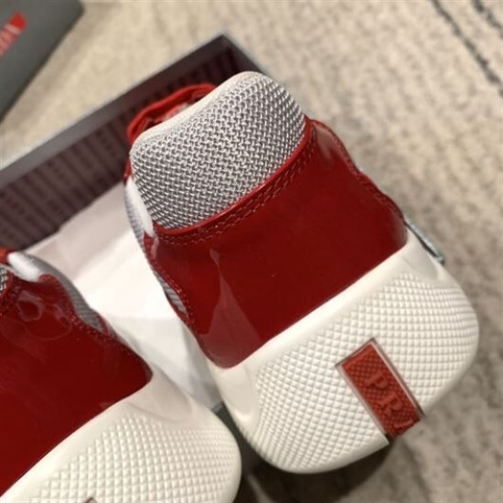 Rear heel view of Prada trainer showing red logo inset on white rubber sole in red and grey