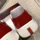 Rear heel view of Prada trainer showing red logo inset on white rubber sole in red and grey
