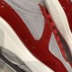 Close-up of red patent leather panels, grey mesh weave and side ventilation eyelets
