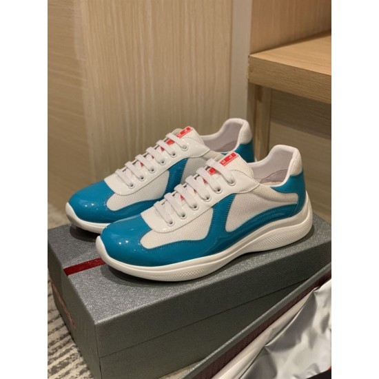 Pair of Prada America's Cup blue patent and white mesh trainers resting on box
