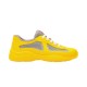 Studio profile view of yellow Prada soft rubber trainer on plain background in yellow and grey
