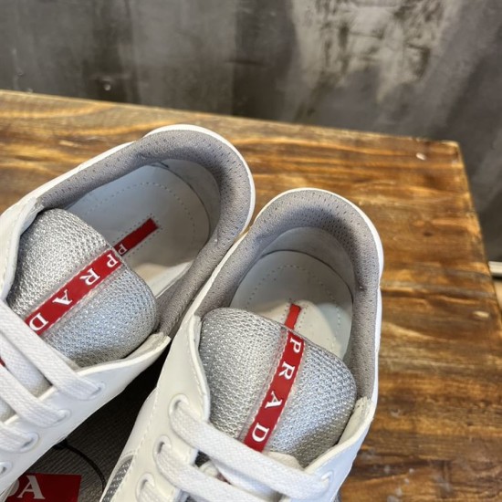 Close-up view of padded collar and red logo tab on tongue in white and grey