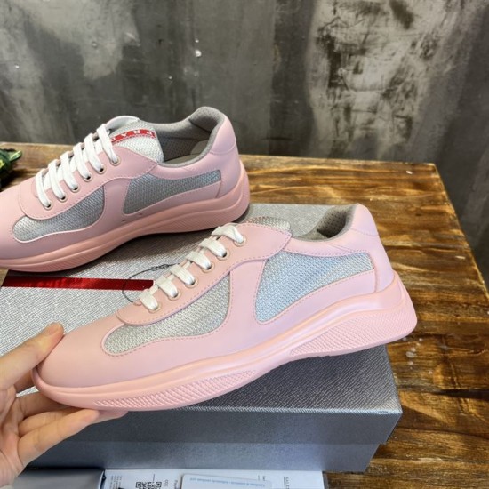 Hand holding a pink trainer showcasing inner side panelling in pink and grey