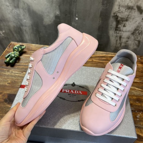 Hand holding a pink and grey trainer showing outer side rubber trim