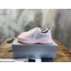 Pair of Prada pink low top trainers sitting on a silver box in pink and grey