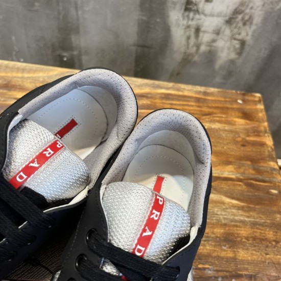 Interior and Tongue Detail Prada Trainers in black and grey Detailed view of padded collar, interior lining and red logo tongue tabs on Prada trainers in black and grey