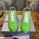 Top-down front angle of green rubber trainers with white laces and grey mesh