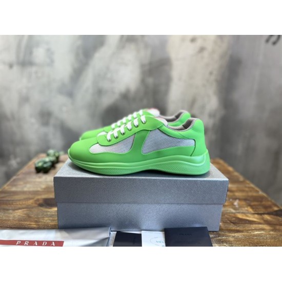 Pair of green and grey low-top trainers sitting on top of a grey shoe box