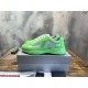 Pair of green and grey low-top trainers sitting on top of a grey shoe box