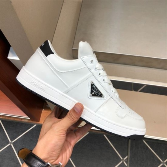 Prada Downtown Trainer Lateral View in white and black Hand holding Prada Downtown white leather trainer highlighting the outer side logo in white and black