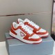 Pair of Prada Downtown Leather Trainers on Box in orange and white Pair of orange and white Prada Downtown leather trainers resting on a grey shoebox