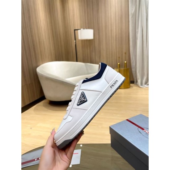 Prada White Trainer Lateral Side Profile in white and navy Hand holding Prada white trainer showcasing the side profile and logo emblem in white and navy