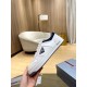 Prada White Trainer Lateral Side Profile in white and navy Hand holding Prada white trainer showcasing the side profile and logo emblem in white and navy