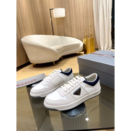Prada White And Navy Low-Top Trainers Pair View Pair of Prada white and navy low-top trainers displayed on a glass table next to a shoebox