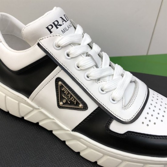 Prada Leather Low Top Trainers In Black And White - Logo Close-Up Extreme close-up of leather upper and enamel triangle logo on Prada trainer in black and white