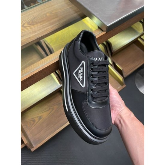 Handheld Profile of Prada Black Trainer in black and white Handheld angle of a black Prada Re-Nylon trainer displaying the platform sole with white stripe accent.