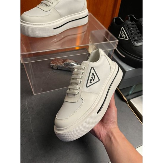 Prada Macro Platform Trainer in Hand in off-white Hand holding off-white Prada Macro platform trainer angled view