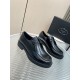 Prada Brushed Leather Monolith Pair View in black Pair of black Prada brushed leather lace-up shoes resting on a glass surface