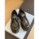 Top front view of black Prada Monolith shoes showing enamel triangle logo