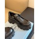 Single black Prada Monolith shoe positioned on white shoe box