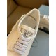 Prada Monolith Triangle Logo Badge Close-Up in white Close-up of metallic enamel logo badge on white leather tongue of Prada shoe