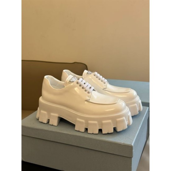 Prada Monolith White Shoes Pair Perspective View Pair of Prada Monolith white brushed leather shoes displayed on blue shoe box