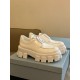 Prada Monolith White Shoes Pair Perspective View Pair of Prada Monolith white brushed leather shoes displayed on blue shoe box