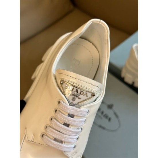 Prada Monolith White Shoe Tongue Logo Detail Detailed view of enamel triangle logo and laces on white Prada Monolith shoe