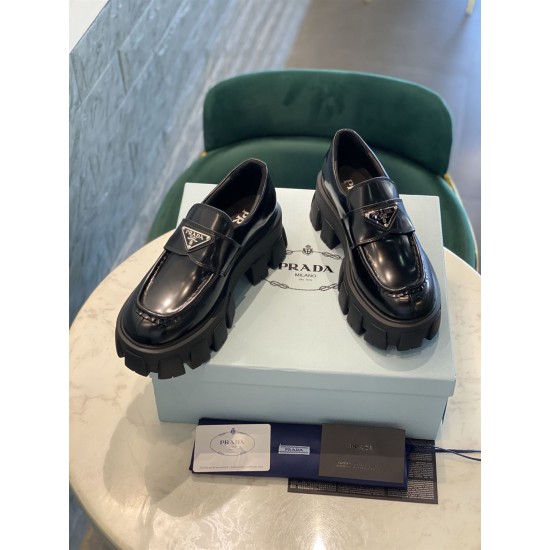 Prada Monolith Loafers Box Presentation in black Pair of Prada Monolith black leather loafers displayed on a light blue box