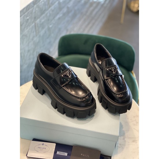 Prada Monolith Loafers Top Angle View in black Pair of black Prada Monolith brushed leather loafers resting on a product box
