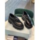 Prada Monolith Loafers Top Angle View in black Pair of black Prada Monolith brushed leather loafers resting on a product box