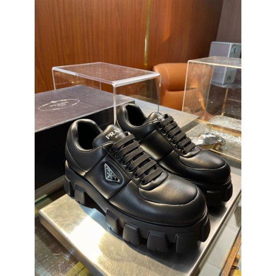Prada Black Padded Nappa Trainers Pair Display Pair of black Prada soft padded nappa leather trainers with chunky soles displayed on a glass shelf