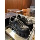 Prada Black Padded Nappa Trainers Pair Display Pair of black Prada soft padded nappa leather trainers with chunky soles displayed on a glass shelf