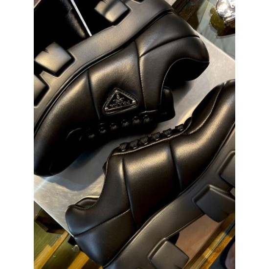 Prada Black Padded Trainer Side Detail Close-up side detail of two Prada black padded leather trainers showcasing stitch lines and enamel triangle logo