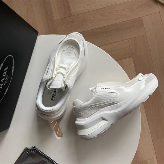 Top View Prada White Low Top Trainers Top-down view of white Prada low top trainers resting on a round table