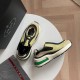 Prada Systeme Yellow and Black Mesh Trainers Angle View Prada Systeme yellow and black mesh trainers display on table