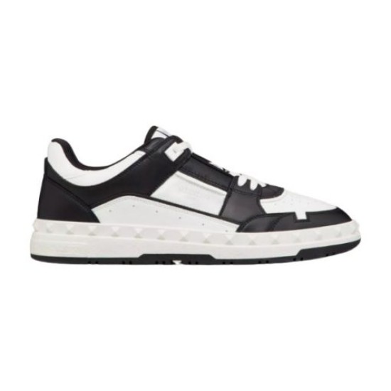 Isolated side view of the Valentino Freedots low-top leather trainer in black and white against a plain background.