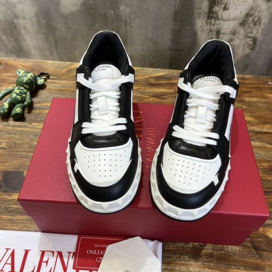Front top-down view showing the perforated toe boxes and white laces of Valentino Freedots black and white trainers.