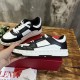 Lateral view of a Valentino Freedots black and white trainer held above its red luxury shoebox.