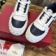 Close-up angled shot of the front perforated navy toe caps and white lacing on Valentino trainers in white and navy blue