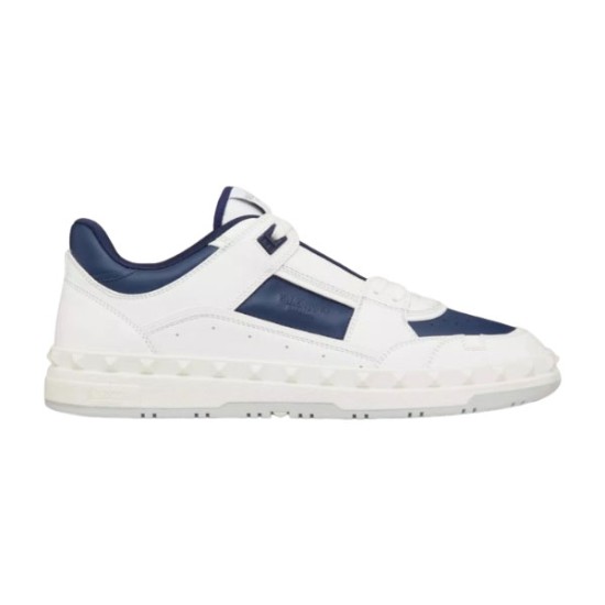 Side profile view of Valentino low-top leather trainers in white and navy blue featuring rockstud midsole trim.