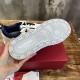 Bottom outsole view displaying rubber tread pattern and embossed Valentino logo in white and navy blue