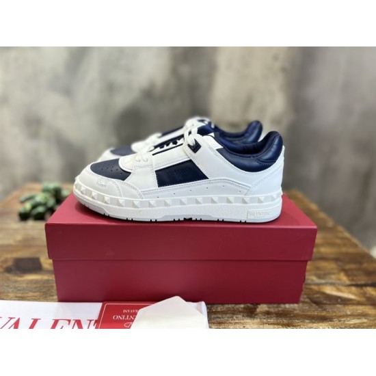 Pair of Valentino low-top white and navy trainers sitting on top of a red shoebox in white and navy blue