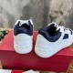 Rear angle view detailing white leather heel counters and rockstud midsoles on Valentino trainers in white and navy blue