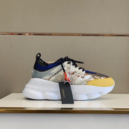 Versace Chain Reaction Trainers Display View in yellow and white Versace Chain Reaction Baroque Pattern Chunky Sole Trainers displayed on a shelf with black branded shoebox in yellow and white