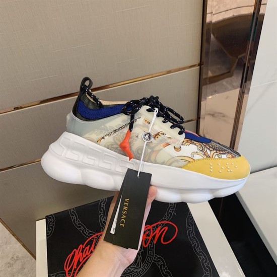 Versace Chain Reaction Trainer Handheld Side View in yellow and white Hand holding Versace Chain Reaction Baroque Pattern Chunky Sole Trainer showing side panel and lace details in yellow and white